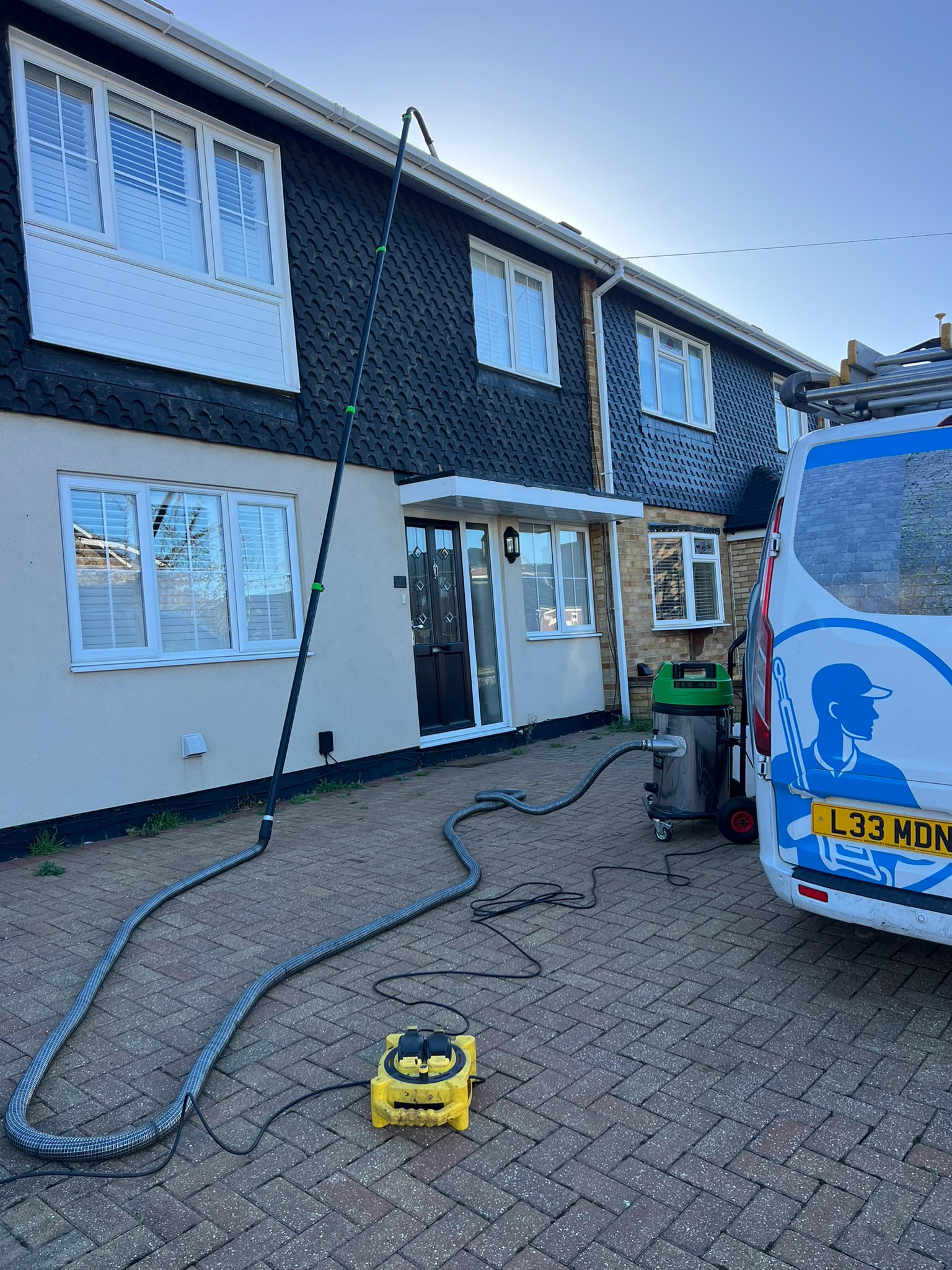 Maddins gutter vacuum pole, suction unit and van outside a two-storey house